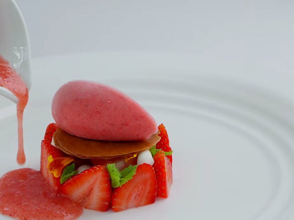 Coulis poured beside a strawberry gelato quenelle