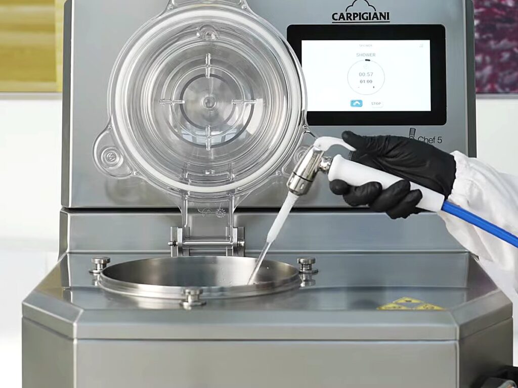 Carpigiani Lab-O-Chef 5: Pastry, Chocolate, Savoury and Gelato from One Countertop Machine 19 Operator rinsing the cylinder with the spray hose