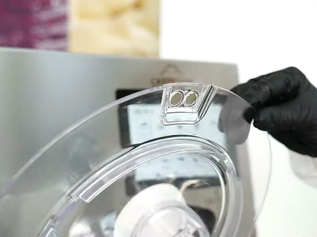 Carpigiani Lab-O-Chef 5: Pastry, Chocolate, Savoury and Gelato from One Countertop Machine 7 Gloved hand lifting the clear lid of the Lab-O-Chef 5