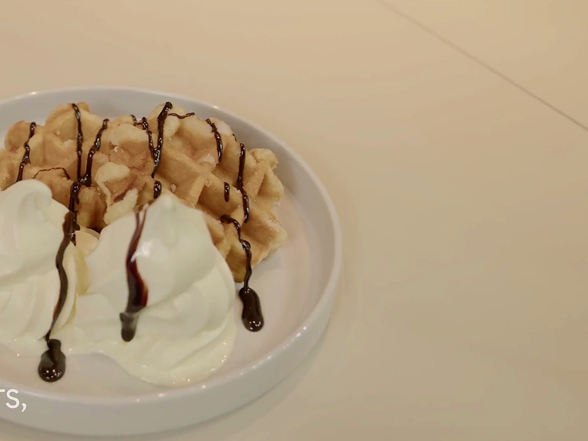 A waffle with soft serve and chocolate.